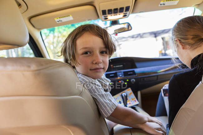Мальчик смотрит в камеру в припаркованной машине. — стоковое фото