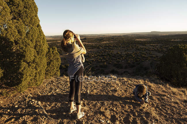 Adolescente che guarda attraverso il binocolo nel bacino del Galisteo, Santa Fe, NM. — Foto stock
