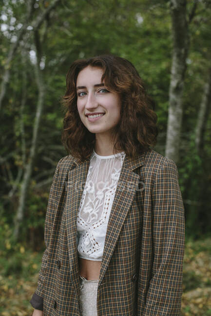 Retrato de una niña feliz de diecisiete años parada en un frondoso bosque en otoño, Discovery Park, Seattle, Washington - foto de stock