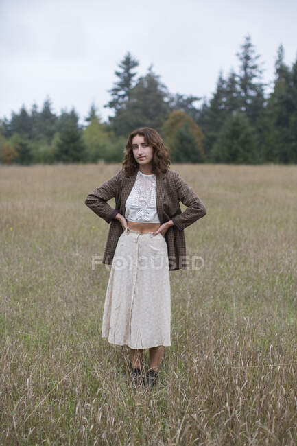 Portrait d'une jeune fille de dix-sept ans portant un blazer en tweed, debout dans un champ d'herbes hautes, Discovery Park, Seattle, Washington — Photo de stock