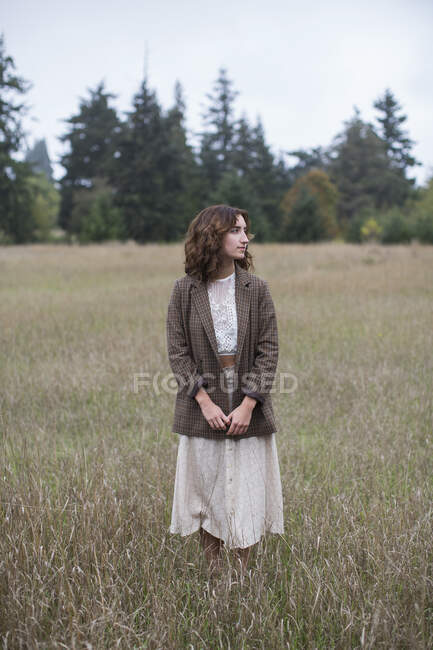 Портрет семнадцатилетней девушки в твидовом пиджаке, стоящей в поле высоких трав, Парк Дискавери, Сиэтл, Вашингтон — стоковое фото