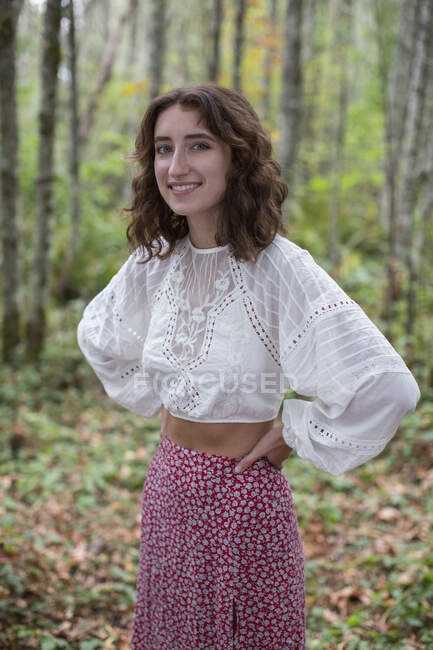 Портрет щасливої сімнадцятирічної дівчини, що стоїть у пишному лісі восени, Діскавері Парк, Сіетл, штат Вашингтон. — стокове фото