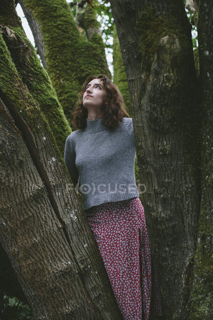 Portrait of seventeen year old girl standing in front of mossy maple tree — Stock Photo