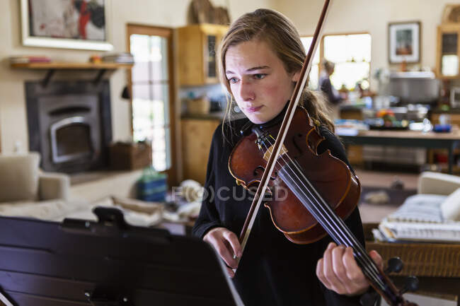 Teenage girl practicing violin at home — Stock Photo