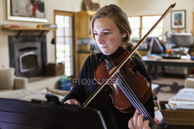 Adolescente che pratica il violino a casa — Foto stock