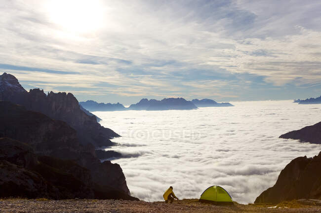Man and tent above the clouds, Trentino-Alto Adige, South Tyrol in Bolzano district, Alta Pusteria, Hochpustertal, Sexten Dolomites, Itália — Fotografia de Stock