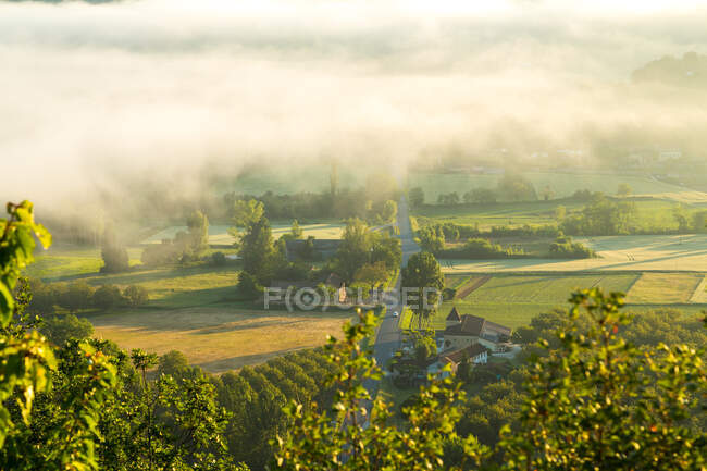 Road and early morning mist, Dordogne, Chateau de Castelnaud, Dordogne, Aquitania, Francia - foto de stock