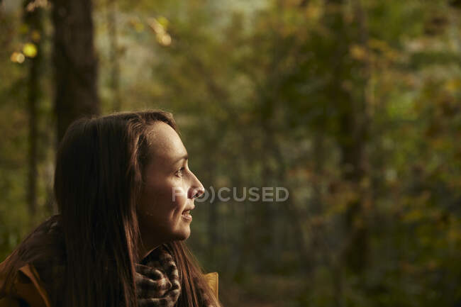 Portrait of woman in woodland, side view — Stock Photo