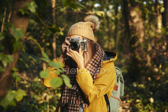 Жінка фотографується з камерою в лісі. — стокове фото
