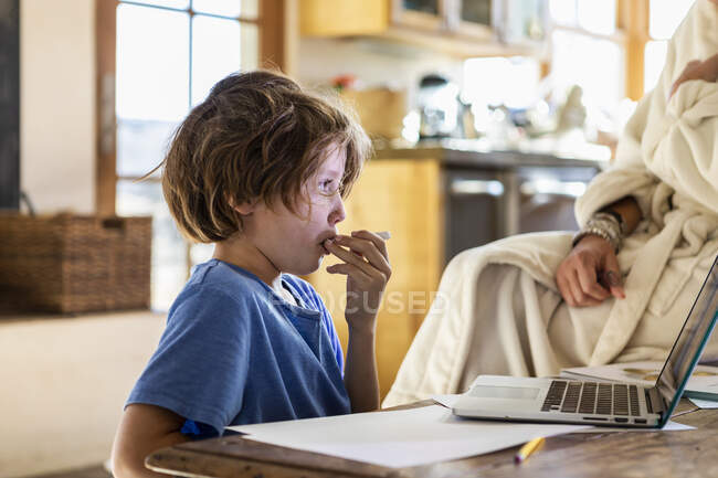 Young boy at home having his temperature taken with a thermometer — Stock Photo