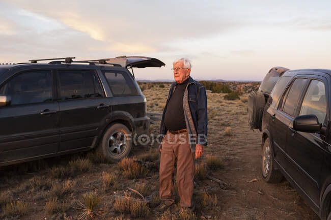 Senior man between SUV cars at sunset, Galisteo Basin, Santa Fe, NM — Foto stock