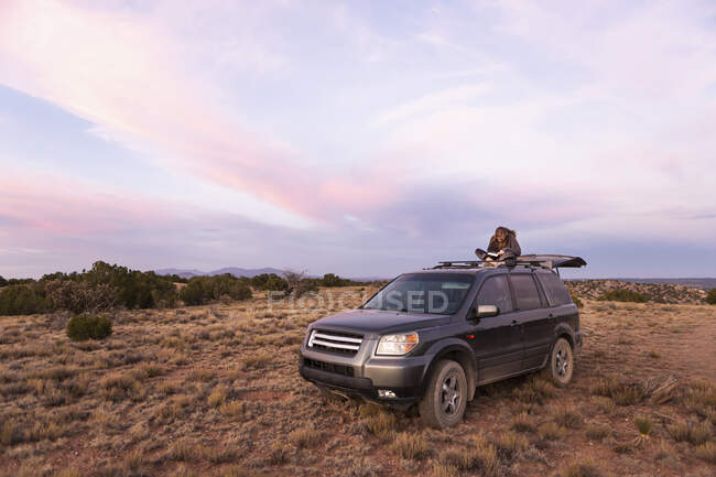 Criança em SUV carro ao pôr do sol, Galisteo Basin, Santa Fe, NM. — Fotografia de Stock