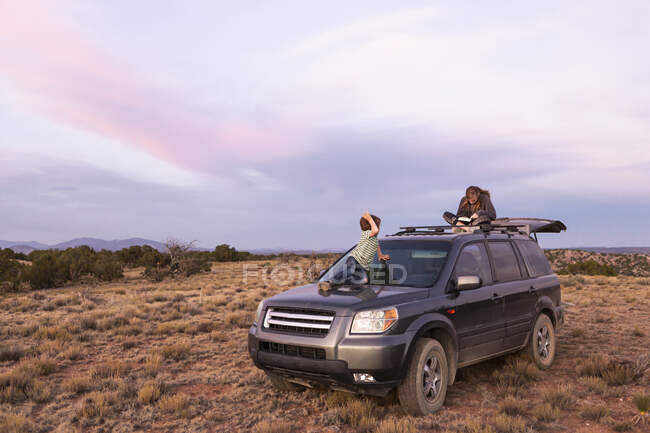 Crianças em SUV carro ao pôr do sol, Galisteo Basin, Santa Fe, NM. — Fotografia de Stock