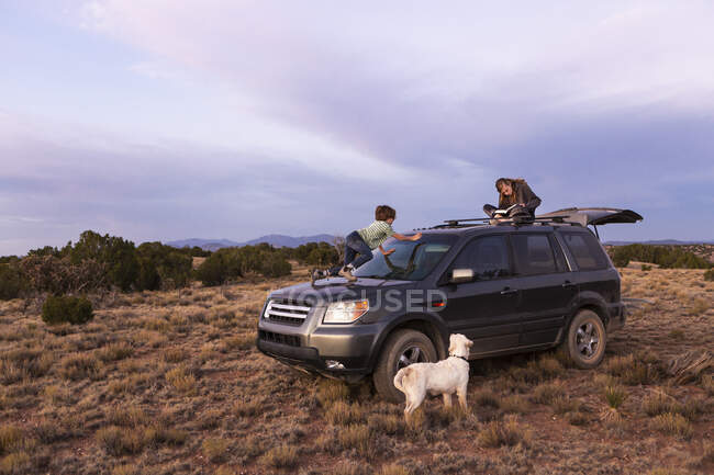 Children on SUV car at sunset, Galisteo Basin, Santa Fe, NM. — Stock Photo