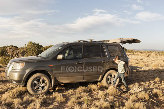 Junge neben einem Geländewagen, Galisteo Basin, Santa Fe, NM. — Stockfoto
