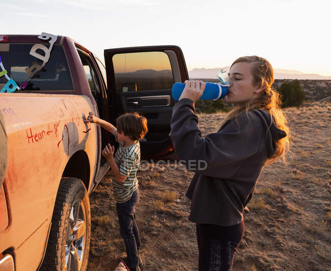 Children writing in the dirt on a pickup truck — Stock Photo