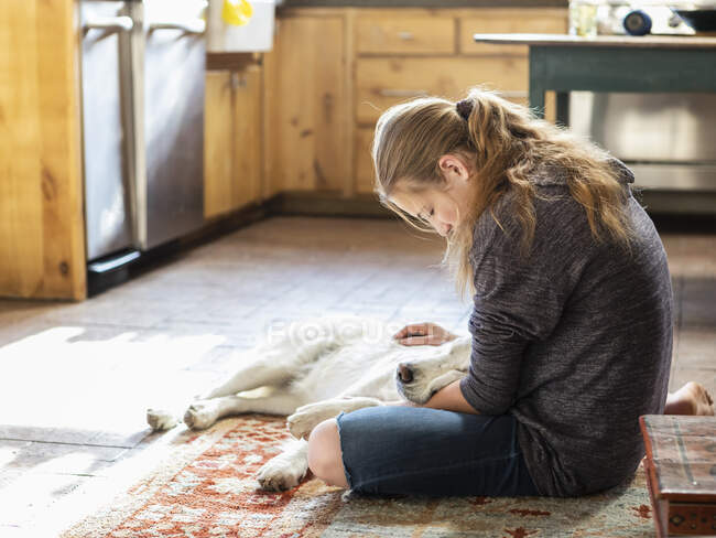Adolescente chica acariciando su Inglés Crema Golden Retriever perro - foto de stock