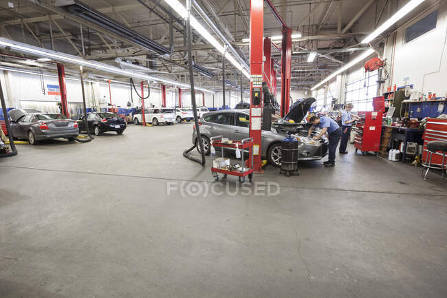 Filas de coches y camiones en taller de reparación de automóviles - foto de stock