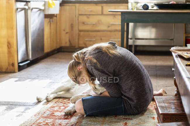 Adolescente chica acariciando su Inglés Crema Golden Retriever perro - foto de stock