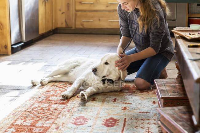 Teenage girl caressing her English Cream Golden Retriever dog — Stock Photo