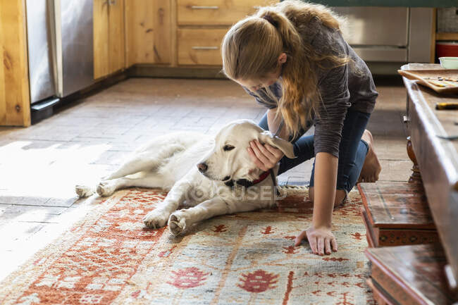 Teenage girl caressing her English Cream Golden Retriever dog — Stock Photo