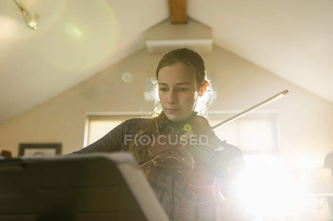 Teenage girl playing her violin in her bedroom — Stock Photo
