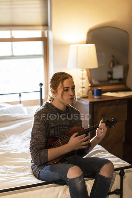 Дівчина-підліток грає на скрипці у своїй спальні — стокове фото