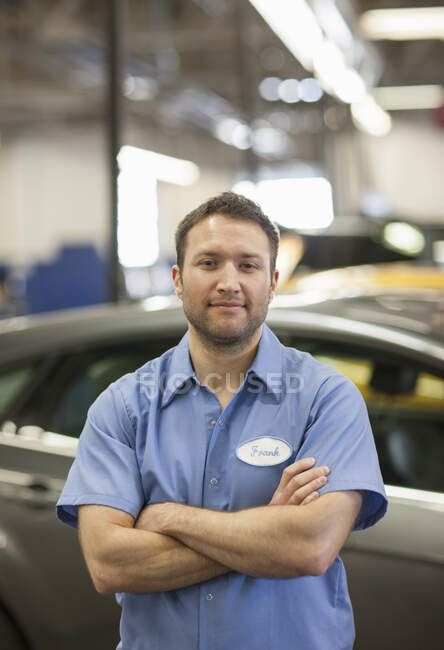 Automechaniker in einer Werkstatt, junger Kaukasier in Uniform mit Namensschild — Stockfoto