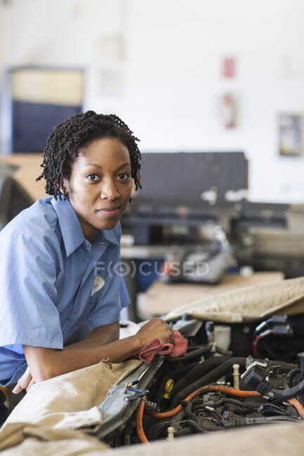 Porträt einer lächelnden schwarzen Mechanikerin in der Autowerkstatt — Stockfoto