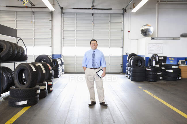 Retrato do proprietário masculino hispânico na oficina de reparação de automóveis — Fotografia de Stock