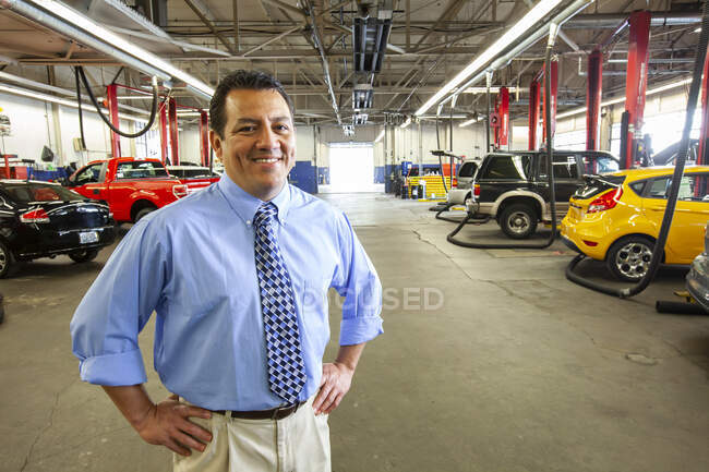 Retrato del propietario de un taller de reparación de automóviles hispano - foto de stock