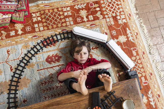 Вид сверху на мальчика, играющего со своим поездом — стоковое фото