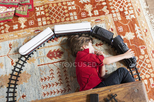 Overhead view of young boy playing with his train — Stock Photo