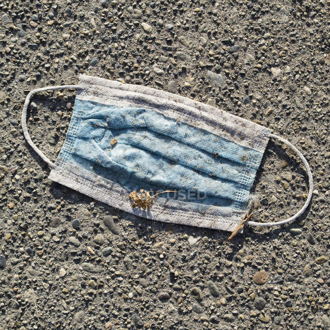 A discarded face mask on the ground — Stock Photo
