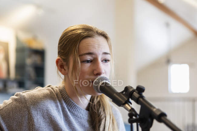 Vierzehnjähriges Teenager-Mädchen spielt Gitarre und singt zu Hause im Dachgeschoss — Stockfoto