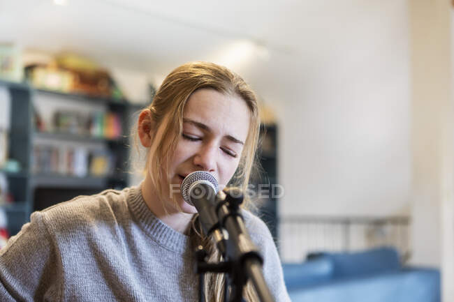 Vierzehnjähriges Teenager-Mädchen spielt Gitarre und singt zu Hause im Dachgeschoss — Stockfoto