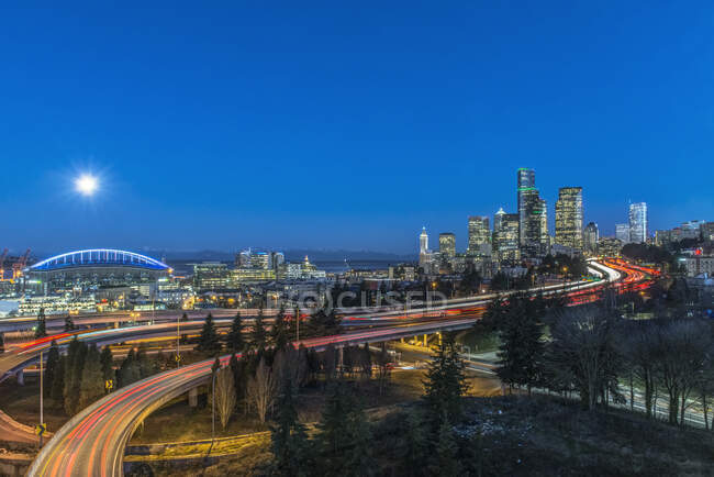 Die Skyline von Seattle bei Nacht, Straße und Brücke, Gebäude in der Innenstadt erstrahlen im Mondlicht. — Stockfoto