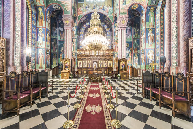 Intérieur d'une église orthodoxe serbe à Ljublijana, peintures murales, piliers et murs peints et lustre. — Photo de stock