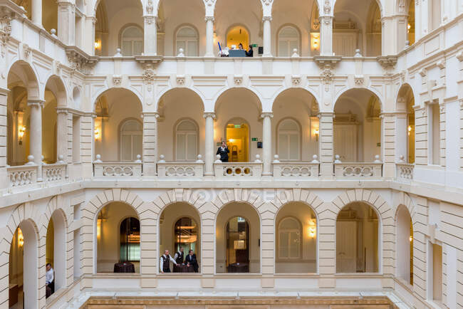 Hotel, ein historisches Gebäude mit Atrium und Gehwegen, klassischer Architektur, Menschen auf jeder Ebene — Stockfoto