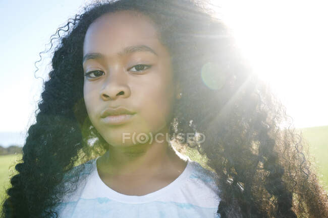 Young mixed race girl with long curly black hair with a serious expression — Stock Photo