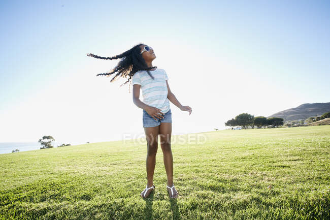 Jovem menina de raça mista fanning seu longo cabelo preto para fora, balançando a cabeça — Fotografia de Stock