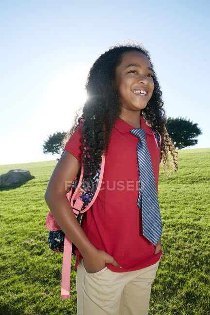 Jovem menina de raça mista em camisa rosa e gravata formal, vestindo uma mochila — Fotografia de Stock