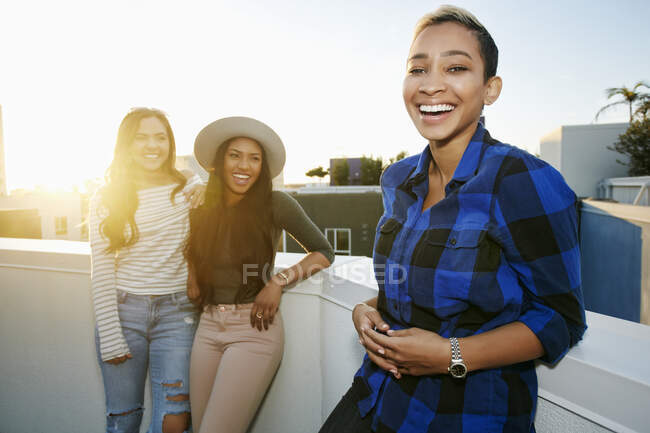 Три молодые женщины на крыше в сумерках — стоковое фото