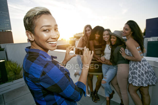Gruppe junger Frauen feiert in der Abenddämmerung auf einem Dach der Stadt — Stockfoto
