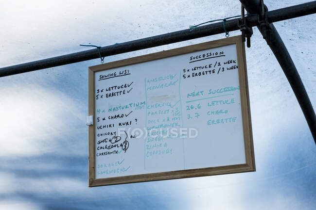 Close up of handwritten vegetable planting checklist in a poly tunnel. — Stock Photo