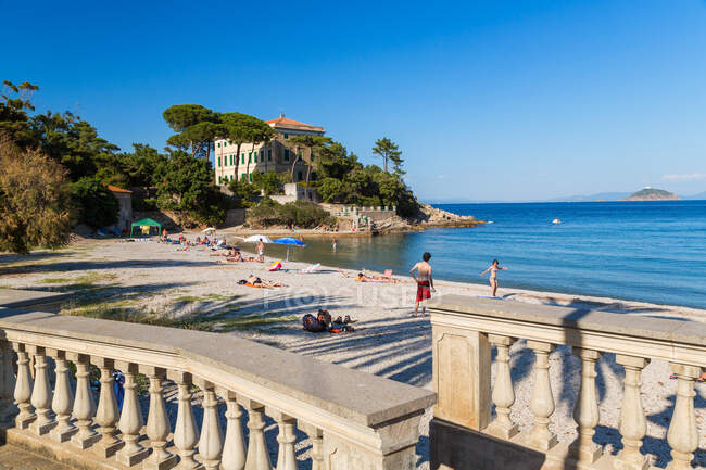 People on the beach and the terrace of a traditional villa, Cavo, Elba. — Stock Photo