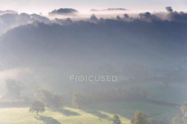 View over Uley village in the Cotswolds, mist and clouds. — Stock Photo