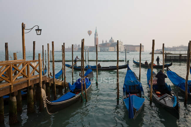 Venice, Gondolas moored at Piazza San Marco, hot air balloon above San Giorgio island — Stock Photo