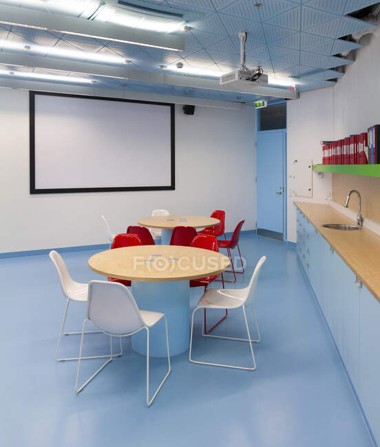 Klassenzimmer mit Whiteboard, runden Tischen und Theke und Waschbecken — Stockfoto