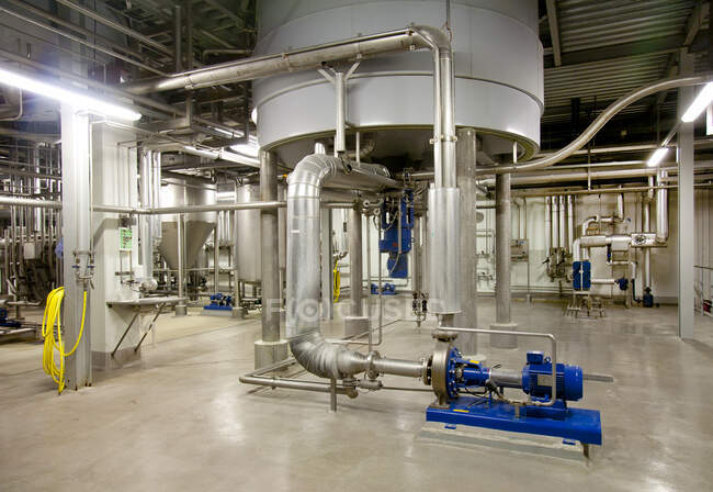Интерьер пивоваренного завода, большие стальные резервуары для пивоварения с металлическими трубами и клапанами. — стоковое фото